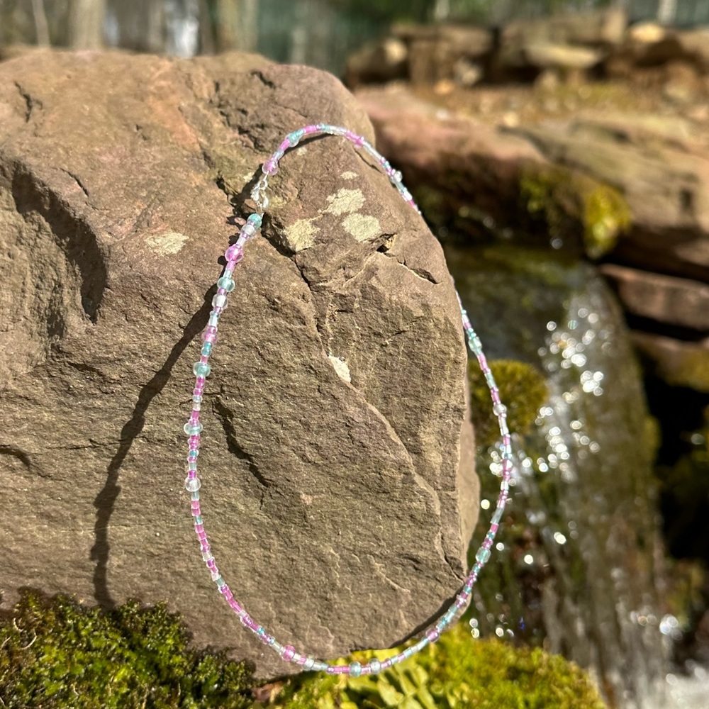Delicate hand crafted 16” glass bead necklace with clasp. Shimmers in the sun